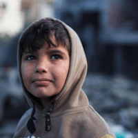 A Palestinian boy at the site of Israeli strikes on a mosque and houses, in Rafah in the southern Gaza Strip on January 25. | Ibraheem Abu Mustafa/ Reuters